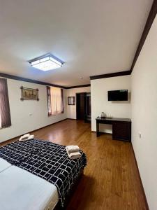 a large bedroom with a bed and a wooden floor at Muhtasham in Bukhara