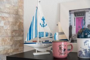 a toy boat sitting on a table next to a mug at Casa Vacanza La Giara in Orosei