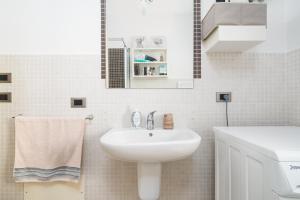 a white bathroom with a sink and a mirror at Casa Vacanza La Giara in Orosei +14 photos