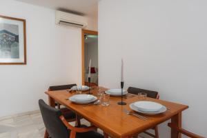 a dining room table with plates and glasses on it at tuGuest Armilla Apartment in Armilla