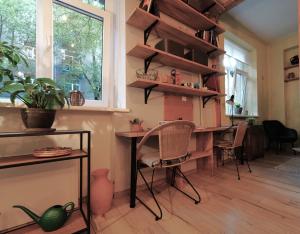 een kamer met een bureau, stoelen en een raam bij Jaukus Butas - Studija centre in Klaipėda