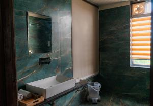 a bathroom with a sink and a mirror at The Sky Imperial Pavoreal Jungle Resort in Kumbhalgarh +24 photos