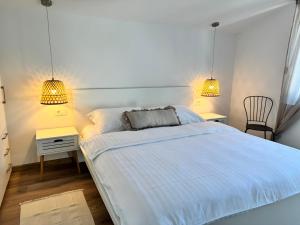 a bedroom with a bed with two night stands and two lamps at Holiday home Prora Mare in Ždrelac