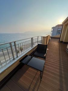 two chairs and a table on a balcony overlooking the beach at La Terrazza di Andreina in Savona