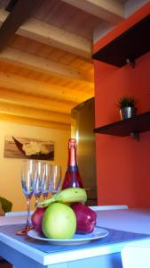 une assiette de fruits et de verres à vin sur un comptoir dans l'établissement Casa Vacanze La Romantica, à Chiavenna