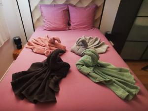 a pink bed with lots of dirty towels on it at Appartement chaleureux proche Disney 44m2 pour 4 pers classé 3 étoiles in Torcy
