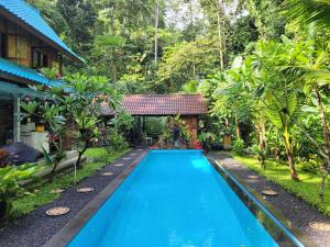 a swimming pool in front of a house at Villa Indayani - 17m Pool - Mt Batur Trek in Tegalalang