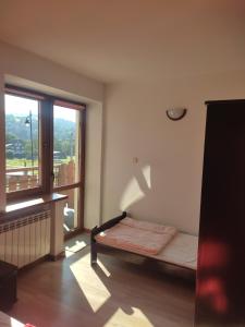 a room with a bed and a large window at Środkowa 20 in Białka Tatrzanska
