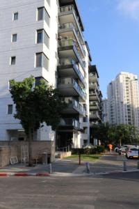 a tall white apartment building in a city at Assuta family in Tel Aviv