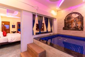 a room with a swimming pool and a bedroom at Auro Beach Resort in Puducherry