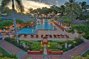 a resort with two pools with tables and chairs at Jayakarta Bali Apartment 6417 in Seminyak