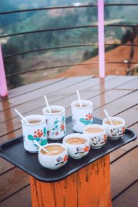 - un plateau avec quatre tasses de café sur une table dans l'établissement Săn Mây Coffee and Homestay Măng Đen, à Kon Von Kla
