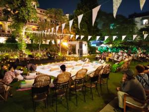 un gruppo di persone sedute intorno a un lungo tavolo di Hotel Arya Niwas a Jaipur
