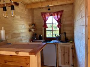une cuisine dans une cabane en rondins avec une fenêtre dans l'établissement Wolf Apex, à Žabljak