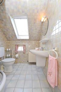 a bathroom with a sink and a toilet and a window at Ferienwohnung im Landhaus Eulennest in Stedesdorf