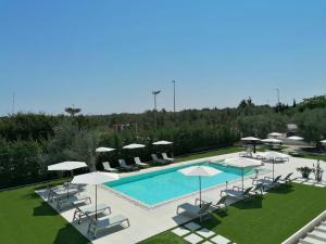 a swimming pool with chairs and umbrellas at Relais Villa Ottavia Bari Airport 10 min in Bitonto
