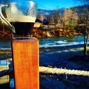 ein Glaskrug Bier auf einem Zaun in der Unterkunft The North Legend in Strîmtura + 14 Fotos