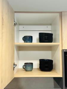 a shelf with three cups sitting on it at PrimVilla Apartment in Gaborone +23 photos