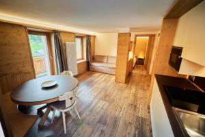 a small room with a table and a couch at Hotel Vallechiara in Bormio +91 photos