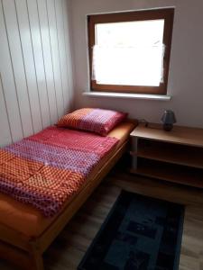 a small bedroom with a bed and a window at Zum Harzblick in Seesen
