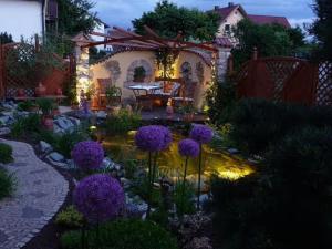 a garden with purple flowers in front of a house at Ferienwohnung Wassergartenparadies in Harsdorf