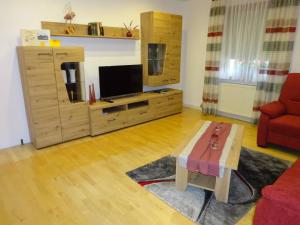 a living room with a flat screen tv and a coffee table at Ferienwohnung Wassergartenparadies in Harsdorf