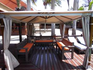 a wooden deck with benches and an umbrella at Budget Tented Village @ Urban Glamping in St Lucia
