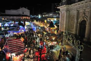 a group of people walking around a christmas market at night at Le Bellevue in Nancy