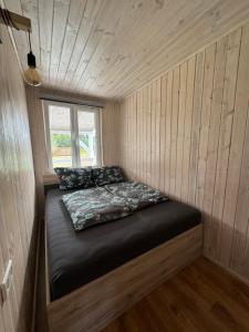 a small room with a bed in a tiny house at Domki Asia - Muszelki 68 in Nowęcin