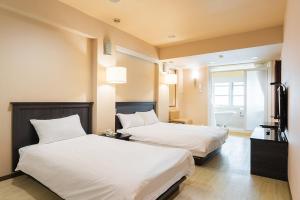 Postel nebo postele na pokoji v ubytování Guide Hotel Kaohsiung Shinkuchan