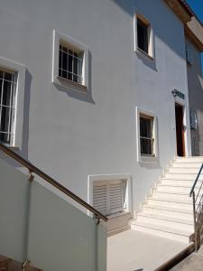 a white building with stairs in front of it at Mimi's Apartments, Palasë in Palasë