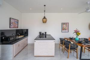 a kitchen and dining room with a table and chairs at Kubung 2 - NEW listing Promo - Canggu - Big Pool and Kitchen in Kerobokan +8 photos