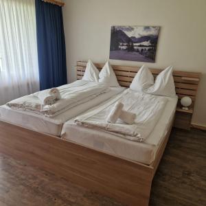 a large bed with white sheets and towels on it at I dr Rehwiesa B02 in Arosa