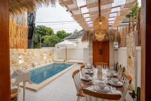 a dining room with a table and a swimming pool at Villa Tropical Terrazzo 2BR Private Pool in Jimbaran