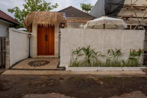 a house with a fence and a wooden door at Villa Tropical Terrazzo 2BR Private Pool in Jimbaran