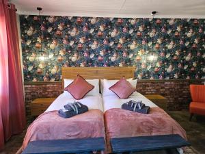 a bedroom with two beds and a floral wall at Motheo Adventure Farm Resort and Spa in Kimberley +12 photos
