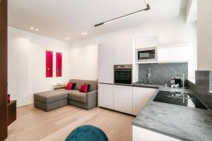 cocina y sala de estar con armarios blancos y sofá en Rubini Suites - by MyHomeInComo, en Como 33 fotos más