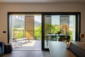 a living room with a sliding glass door with a table at Casa 32 Loft - Garda Lake in Nago-Torbole
