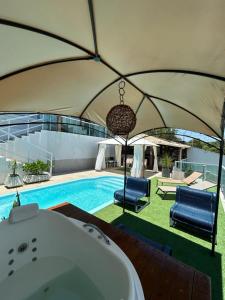 a bath tub in a tent next to a swimming pool at Casa com piscina área gourmet Enseada Azul in Guarapari