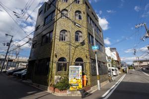 a tall brick building on the corner of a street at Universal Point House in Osaka