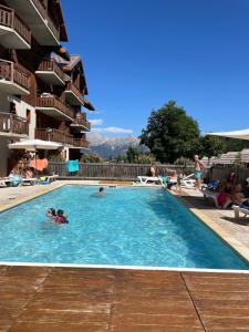a group of people swimming in a swimming pool at Puy St Vincent 1800 au pied des pistes in Puy-Saint-Vincent