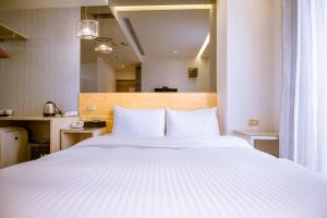 a bedroom with a large white bed with white pillows at CHECK inn Express Taichung FuXing Hall 2 in Taichung