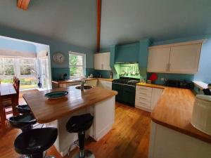 a kitchen with white cabinets and a wooden counter top at Heath House Loch Ness in Errogie