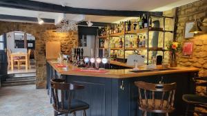 a bar in a restaurant with two bar stools at Unicorn Inn in Deddington