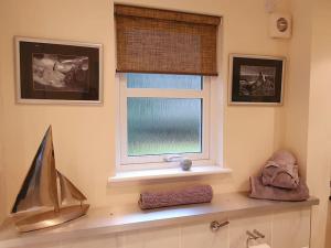 a bathroom with a window and a counter with a sink at Heath House Loch Ness in Errogie +59 photos