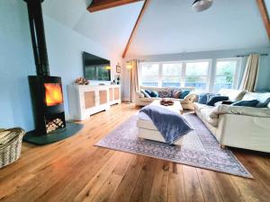 a living room with a couch and a fireplace at Heath House Loch Ness in Errogie