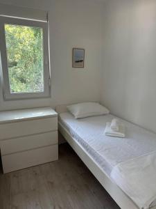 Un dormitorio con dos camas y una ventana. en Stone Village Suite Kamenari, en Kamenari