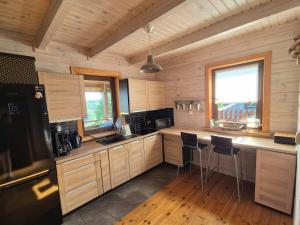 a kitchen with wooden cabinets and chairs in a cabin at GÓRSKA SIELANKA in Istebna