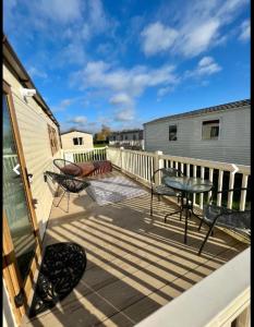a patio with a table and chairs on a deck at Tattershall Lakes in Tattershall