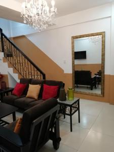 a living room with a couch and a mirror at Jil's Apartelle in Tagaytay